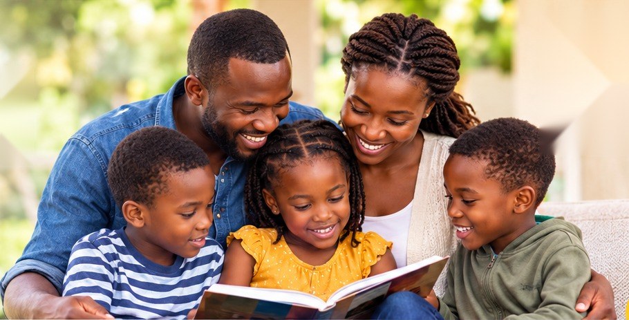 A father, mother and two children reading a book together